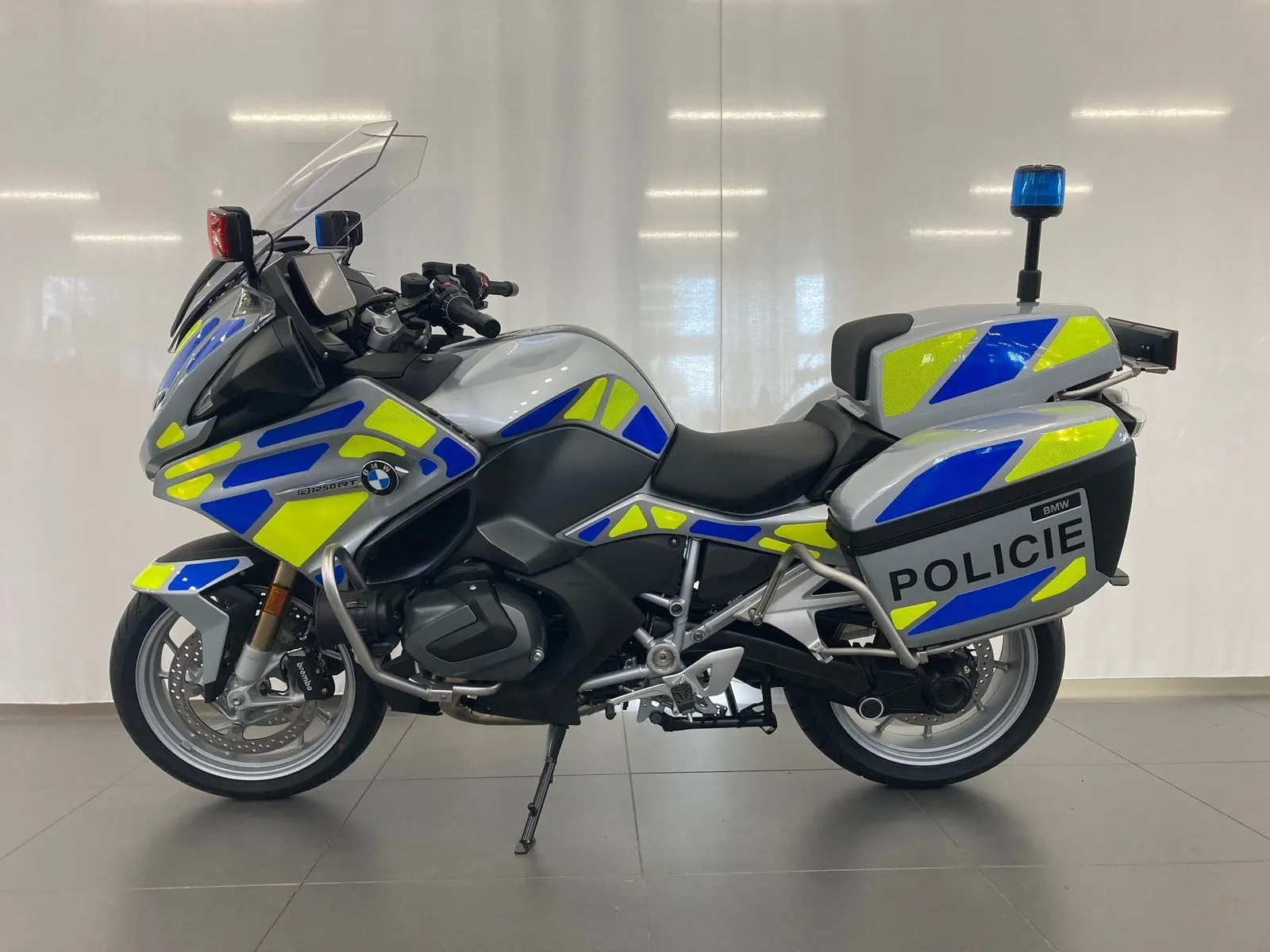 Moderní motocykl BMW s policejním polepem a výstražnými světly.
