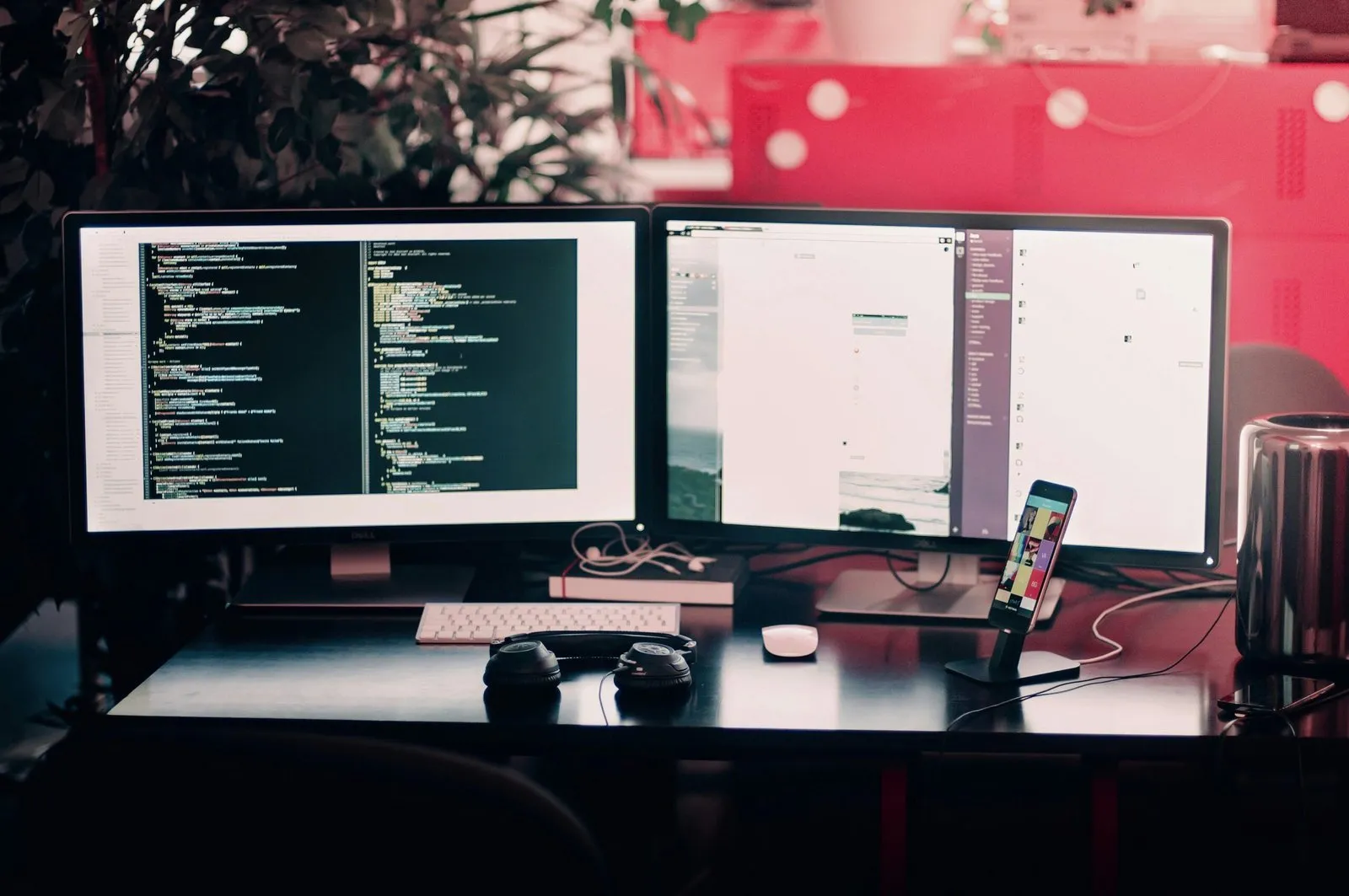 Dva monitory na stole s kódem a multicanálovým zobrazením, vedle sluchátka a telefon.