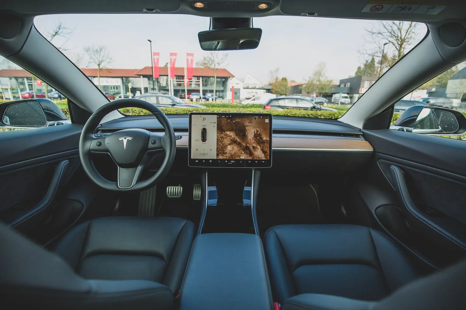 Interiér automobilu Tesla s moderním designem a velkým displejem.