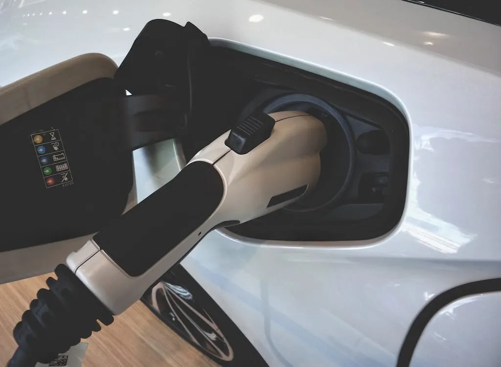 Nabíjecí kabel připojený k elektromobilu v nabíjecí stanici.